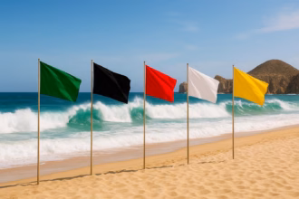 Cinco Mástiles Alineados En La Arena Con Las Banderas De Seguridad Verde, Negra, Roja, Blanca Y Amarilla Frente Al Mar Para Indicar El Sistema De Banderas En La Playa.
