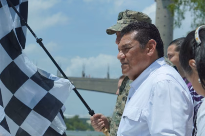 El Gobernador Javier May Rodríguez Sosteniendo Una Bandera A Cuadros En El Muelle De Villahermosa Para Dar El Banderazo De Salida A La Carrera Motonáutica.