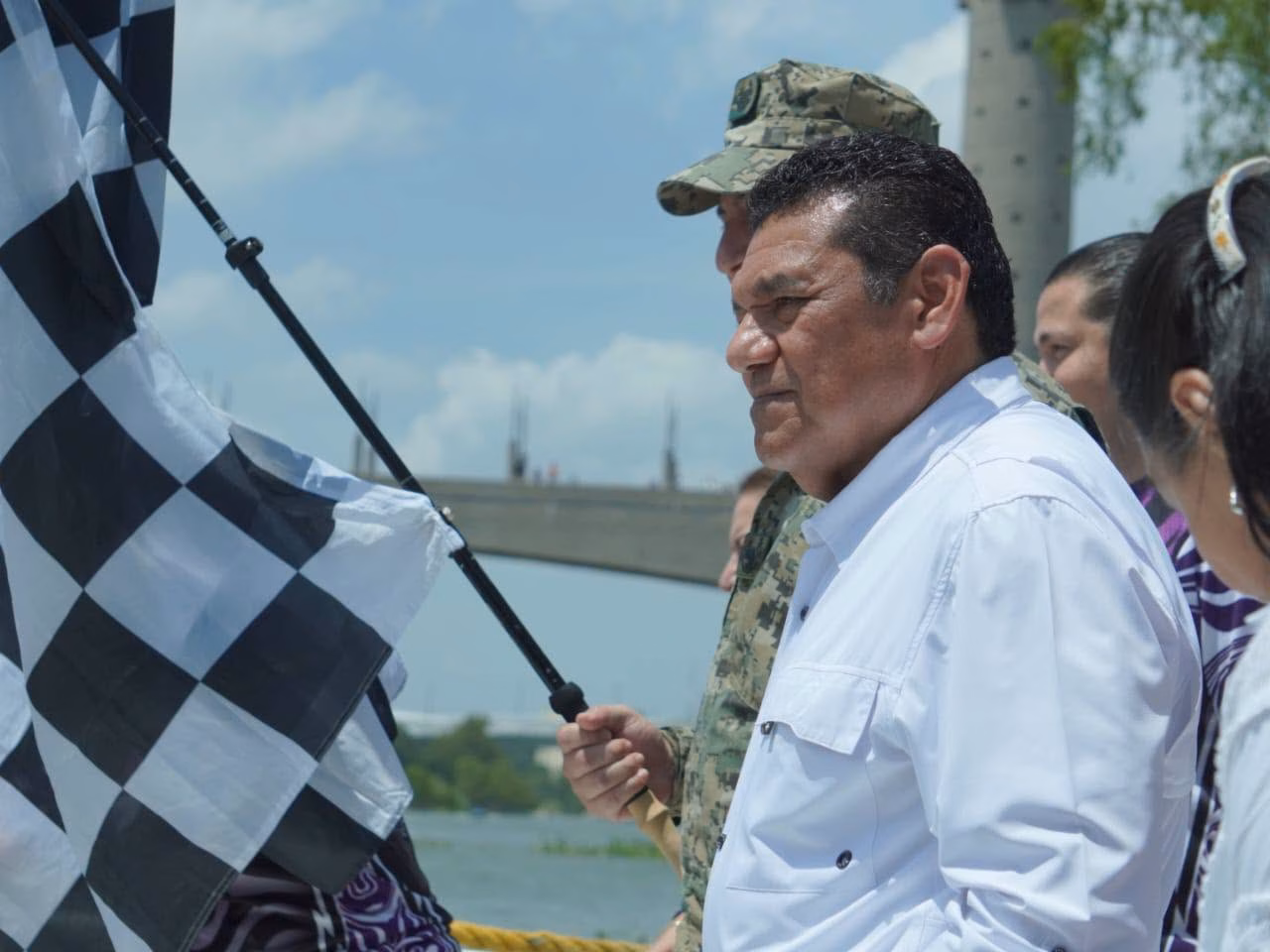 El Gobernador Javier May Rodríguez Sosteniendo Una Bandera A Cuadros En El Muelle De Villahermosa Para Dar El Banderazo De Salida A La Carrera Motonáutica.