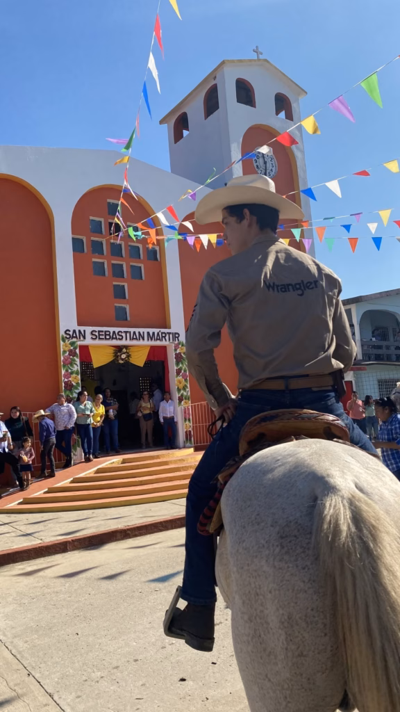 Jinete Montando Un Caballo Blanco Frente A La Iglesia De San Sebastián Mártir Durante Una Cabalgata Como Patrimonio Cultural Intangible De Tabasco, Rodeado De Banderines Y Asistentes A La Celebración.