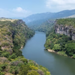 Vista Aérea Del Río Grijalva Fluyendo A Través De Un Impresionante Cañón Rodeado De Vegetación Y Acantilados.
