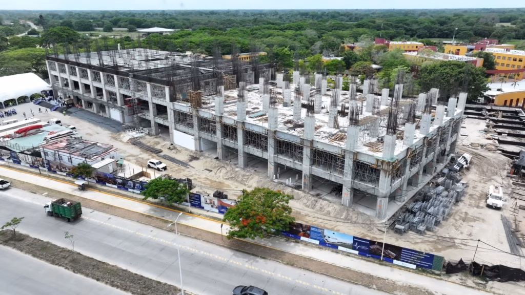 Vista Aérea De La Gran Estructura De Concreto En Construcción Del Hospital Zumaya En Villahermosa, Tabasco, Rodeada De Áreas Verdes Y Frente A Una Avenida.