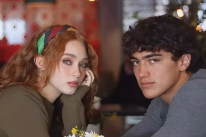 Daniela Martínez Y Tristán Maze, Protagonistas De La Serie De Netflix 'Proyecto Final', Miran Fijamente A La Cámara Sentados En Una Mesa De Restaurante Con Un Florero En Dominion Polanco.