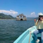 Texto Alternativo La Conductora Vania Manzano Viaja En Una Lancha Sobre El Embalse De La Presa Malpaso Mientras Observa La Fachada Del Templo De Santiago, Conocida Como La Iglesia De Quechula En Chiapas, Emergiendo Del Agua.