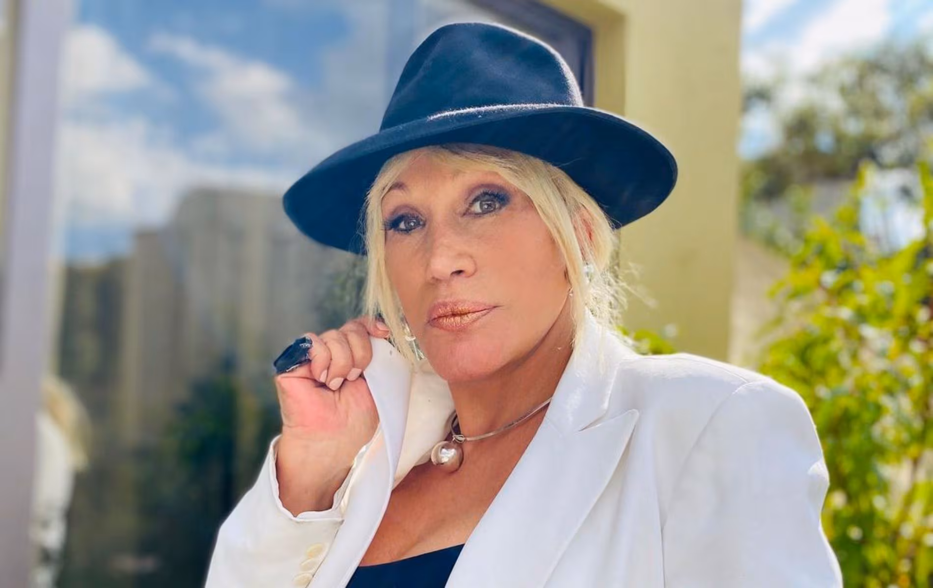 ¡El Tesorito Y Sus Virtudes! Laura León Prepara Su Libro Y Alista Un Deslumbrante Regreso A La Música 72 La Cantante Y Actriz Tabasqueña Laura León Posando Al Aire Libre Con Un Sombrero Negro, Saco Blanco Y Un Collar Esférico Metálico.