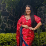 La Creadora De Contenido Ninna Isabel Luciendo Un Sari Tradicional De Color Rojo Y Azul, Posando Sonriente