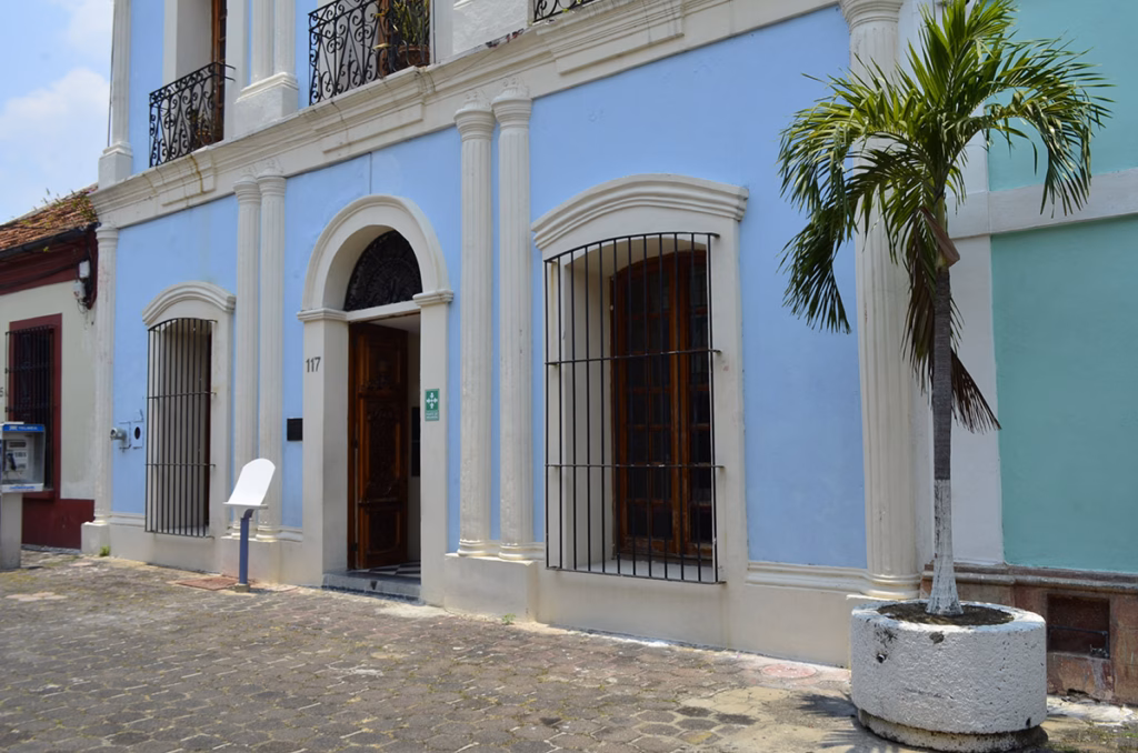 Fachada De Estilo Neoclásico En Color Azul Claro Con Detalles Blancos De La Galería De Arte &Quot;El Jaguar Despertado&Quot;, Ubicada En Una Calle Empedrada Del Centro Histórico De Villahermosa.