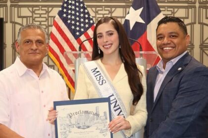Fátima Bosch Fernández Sostiene La Proclamación Oficial De Su Día En Houston Junto A Funcionarios Municipales Y La Bandera De Estados Unidos Y Texas De Fondo.
