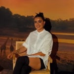 Paulina Gaitán Posando En Una Silla Frente A Un Fondo De Sabana Africana.