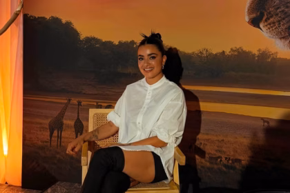 Paulina Gaitán Posando En Una Silla Frente A Un Fondo De Sabana Africana.