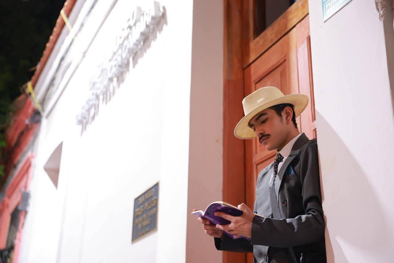 ¿Qué Hacer El Viernes En Villahermosa? Vive La Magia Del Teatro Itinerante Con &Amp;Quot;Voces Del Grijalva&Amp;Quot; 72 Actor Caracterizado Como Un Poeta Tabasqueño Leyendo Un Libro Frente A Un Edificio Histórico Durante El Recorrido Teatral Voces Del Grijalva En El Centro Histórico De Villahermosa.