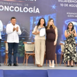 El Gobernador Javier May Y Autoridades De Tabasco Aplauden Junto A Dos Mujeres Que Sostienen Un Reconocimiento Durante El Inicio De Obra Del Centro Internacional De Neuro-Oncología Del Hospital Zumaya.