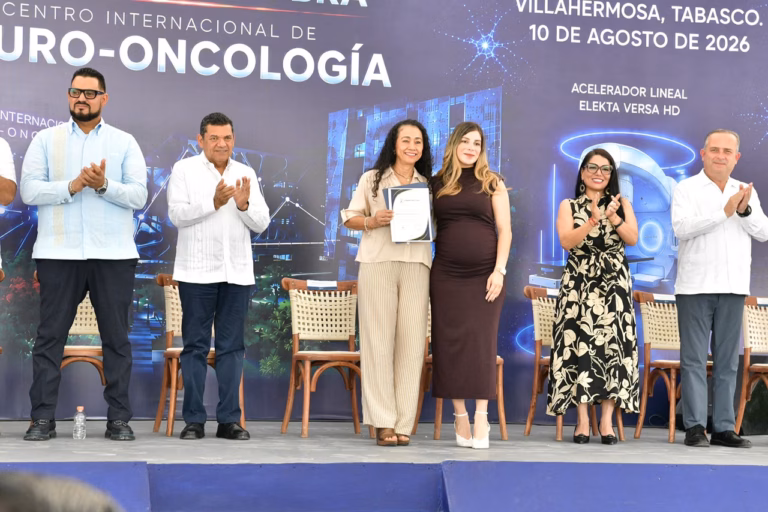 El Gobernador Javier May Y Autoridades De Tabasco Aplauden Junto A Dos Mujeres Que Sostienen Un Reconocimiento Durante El Inicio De Obra Del Centro Internacional De Neuro-Oncología Del Hospital Zumaya.