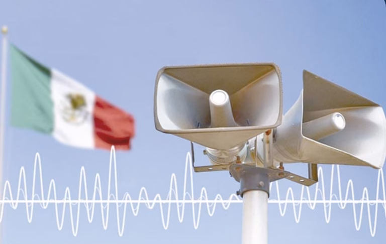Altavoces Del Sistema De Alerta Sísmica Con Ondas Sísmicas Superpuestas Y La Bandera De México Desenfocada Al Fondo Para El Simulacro Nacional 2026 En Tabasco.