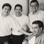 Fotografía En Blanco Y Negro Del Personal Y Fundadores En La Estancia Del Bife 25 Aniversario, Sonriendo Junto A Un Comensal En La Mesa Frente A Un Corte De Carne.