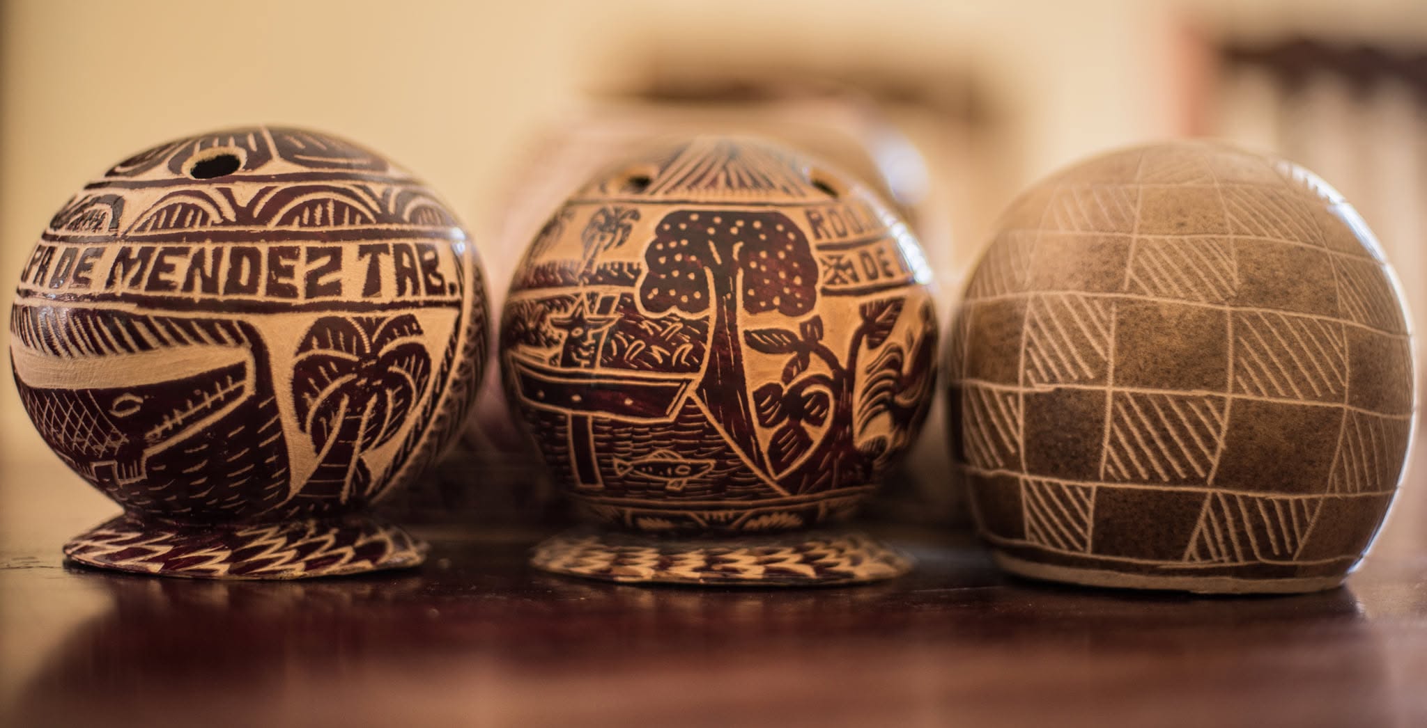 Artesanías En Jícara Y Mimbre De Tapijulapa Y Jalpa De Méndez Jícaras Labradas De Jalpa De Méndez Con Finos Grabados Y Diseños Tradicionales Expuestas Sobre Una Superficie De Madera.