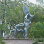 Escultura De Bronce De La Fuente De Los Niños Traviesos En Villahermosa, Mostrando A Tres Niños Jugando Con Una Garza Entre Vegetación Tropical.