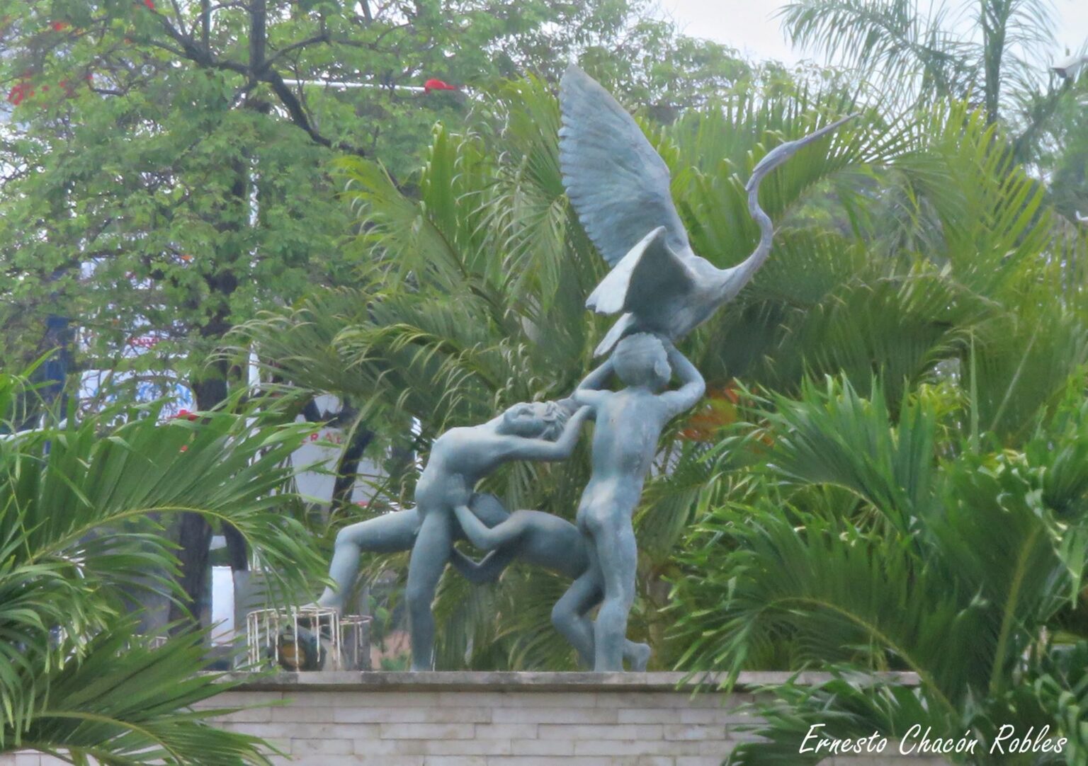 Escultura De Bronce De La Fuente De Los Niños Traviesos En Villahermosa, Mostrando A Tres Niños Jugando Con Una Garza Entre Vegetación Tropical.
