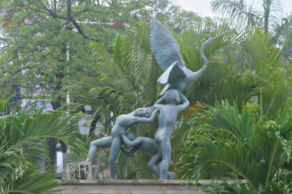 Escultura De Bronce De La Fuente De Los Niños Traviesos En Villahermosa, Mostrando A Tres Niños Jugando Con Una Garza Entre Vegetación Tropical.
