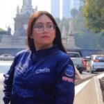La Astronauta Análoga Karla Santander Posando Junto A Una Bandera Conmemorativa Durante Un Evento Del Sector Aeroespacial, Destacando Su Labor En La Divulgación Científica Y Sus Propuestas De Innovación.