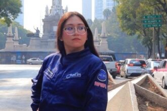 La Astronauta Análoga Karla Santander Posando Junto A Una Bandera Conmemorativa Durante Un Evento Del Sector Aeroespacial, Destacando Su Labor En La Divulgación Científica Y Sus Propuestas De Innovación.