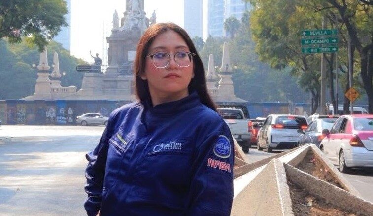 De Tabasco A Las Estrellas: La Innovadora Propuesta De La Astronauta Análoga Karla Santander Para Llevar El Pozol En Misiones Espaciales A Marte La Astronauta Análoga Karla Santander Posando Junto A Una Bandera Conmemorativa Durante Un Evento Del Sector Aeroespacial, Destacando Su Labor En La Divulgación Científica Y Sus Propuestas De Innovación.