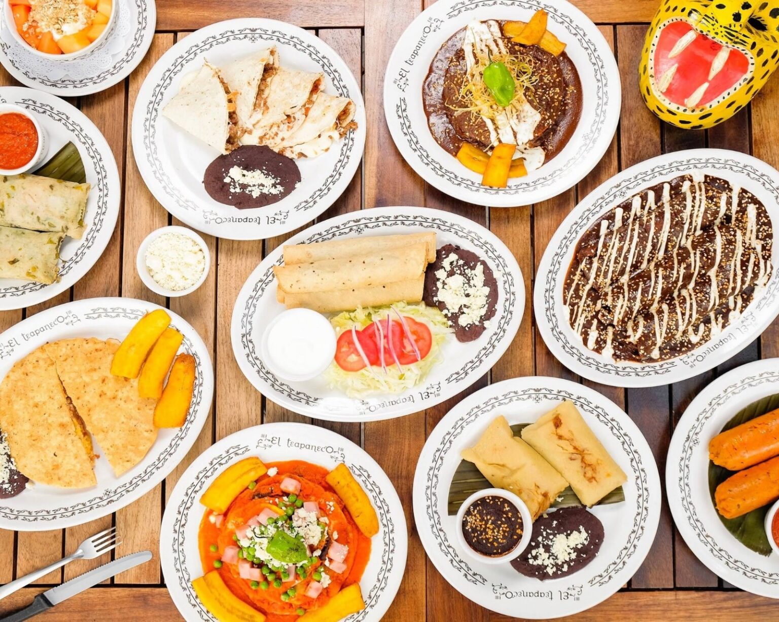 Vista Superior De Una Mesa Con Una Gran Variedad De Platillos Típicos Y Tradicionales De El Teapaneco, Incluyendo Tamales, Antojitos Y Guisados Regionales.