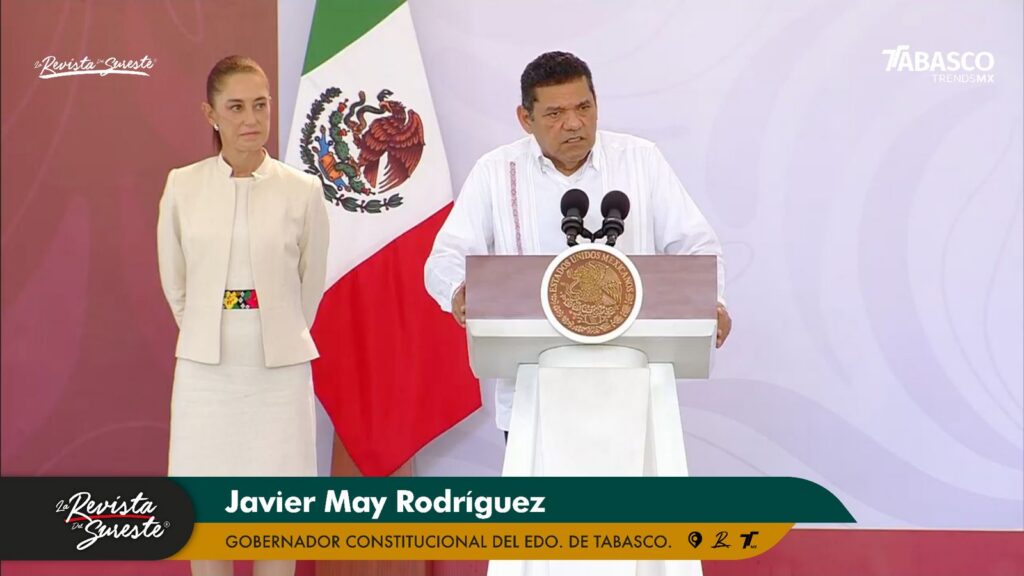 Gira Presidencial En Tabasco: Claudia Sheinbaum Encabeza Mesa De Seguridad Y Presenta Avances Estratégicos En Educación, Campo Y Turismo : El Gobernador Javier May Rodríguez Habla Desde El Atril Con El Escudo Nacional, Acompañado Por La Presidenta Claudia Sheinbaum Frente A La Bandera De México.