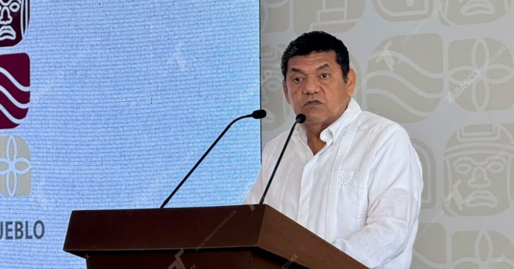 Javier May Consolida La Transformación Integral De Tabasco Con Acciones En Seguridad, Desarrollo Social, Impulso Al Campo Y Fomento Al Deporte 73 El Gobernador Javier May Rodríguez De Pie En El Pódium De Madera Con Guayabera Blanca, Hablando Frente A Micrófonos Durante Su Conferencia Matutina Oficial.
