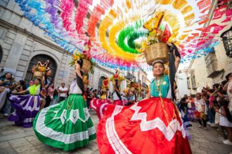 Bailarinas Con Coloridos Trajes Tradicionales Y Canastas En La Cabeza Durante El Desfile Previo A Las Presentaciones De La Guelaguetza.
