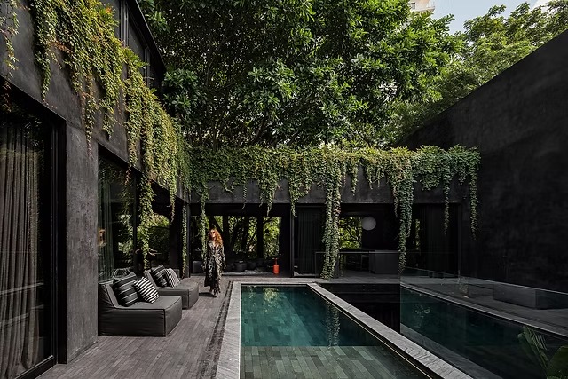 Orgullo Tabasqueño En Europa: Casa Roca De Yiyicaru Arquitectos Galardonada En La 8.ª Edición De Los Design Educates Awards En Polonia 72 Diseño Arquitectónico De Casa Roca Con Fachada Monolítica En Color Negro Absoluto, Piscina Central Reflectante Y Vegetación Abundante.