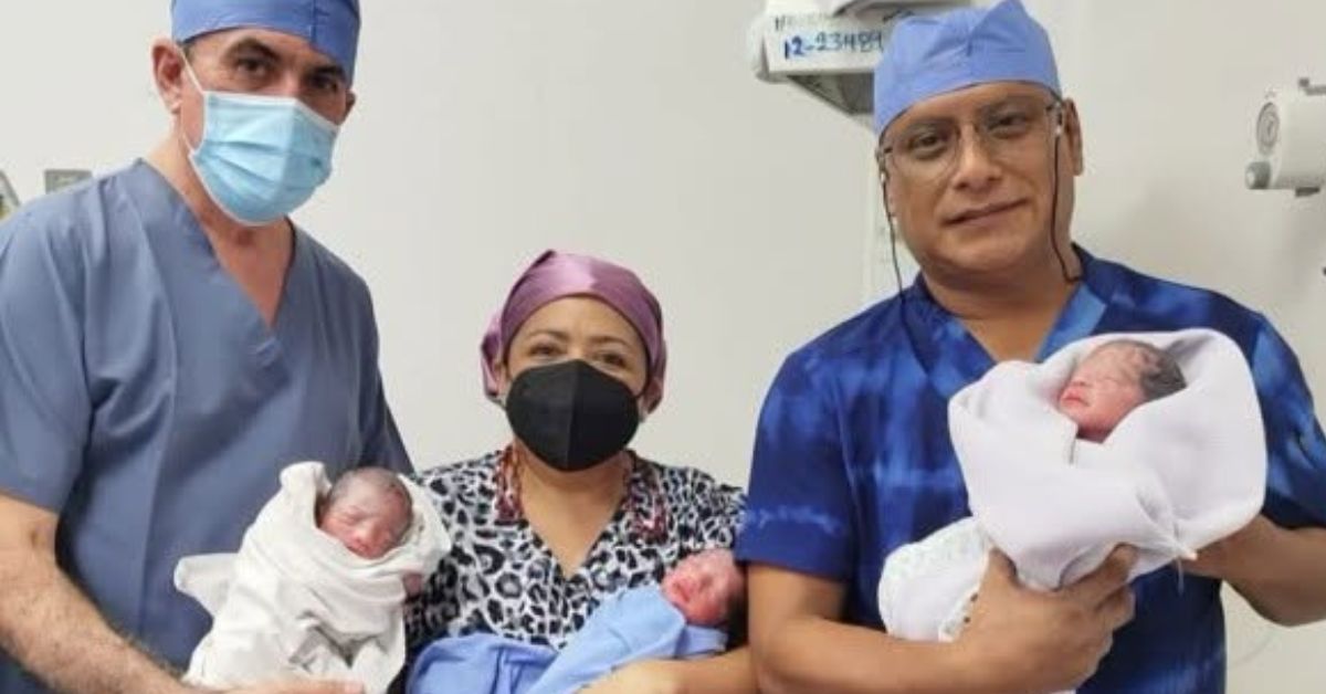 Tres Profesionales De La Salud Con Uniforme Quirúrgico Sosteniendo En Brazos A Trillizos Recién Nacidos Envueltos En Mantas Dentro De Un Quirófano En Tabasco.
